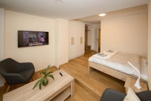 a room with a bed and a chair and a table at Apartmán nad Ottovkou in Luhačovice