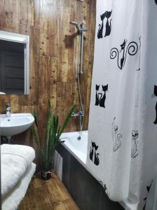 uma casa de banho com uma cortina de chuveiro com gatos em Апартаменти в центрі Хмельницького (біля ТРЦ ЛибідьПлаза) em Khmelnytskyi