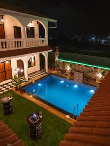 uma piscina em frente a uma casa à noite em Sapphire Mansion em Alībāg