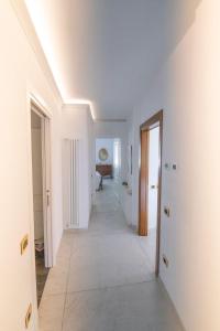 a hallway with white walls and a long white floor at Casa di Anna in Pistoia