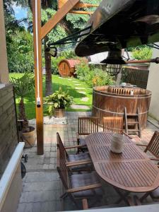 een patio met een tafel en stoelen onder een parasol bij Abigél Vendégház Keszthely in Keszthely