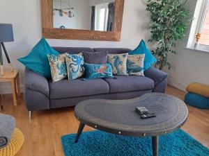 een woonkamer met een paarse bank met blauwe kussens bij Fistral beach apartment in Newquay