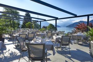 um restaurante com mesas e cadeiras e vista para a água em Hotel Alexander em Weggis