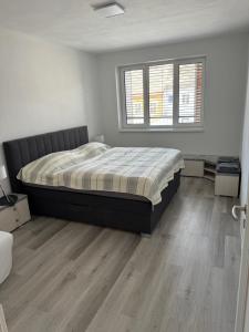 um quarto com uma cama e piso em madeira em Soukromý byt 2+kk s balkónem a parkováním em Znojmo