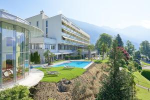 um edifício com piscina e um resort em Hotel Alexander em Weggis