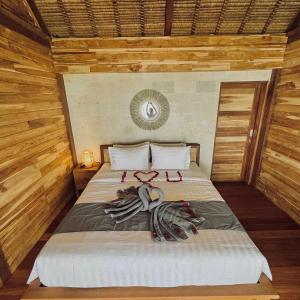 1 dormitorio con 1 cama con toallas en Uma Pantai Seseh, en Canggu