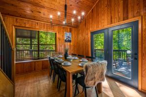 una sala da pranzo con tavolo e sedie di Escape to Sugar Chalet: The Rustic Modern Retreat a Gatlinburg