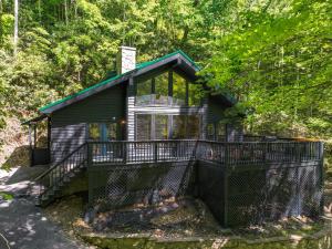 una cabina nel bosco con ponte perimetrale di Escape to Sugar Chalet: The Rustic Modern Retreat a Gatlinburg