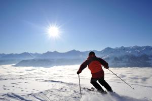 un homme faisant du ski au sommet d'une montagne dans l'établissement Achenblick, à St. Johann in Tirol