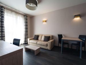 uma sala de estar com um sofá e uma mesa em Ibis Styles Charleroi Airport Aero 44 em Charleroi