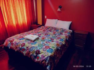 a bedroom with a bed with a colorful comforter at ANDENES DEL TITICACA in Puno