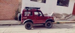 a red jeep parked on the side of a street at ANDENES DEL TITICACA in Puno