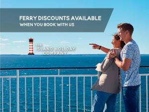 a man and woman standing on a cruise ship with a lighthouse at Jollys in Sandown