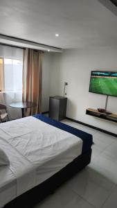 um quarto com uma cama e uma televisão de ecrã plano em Koluti Apartments em Ndola