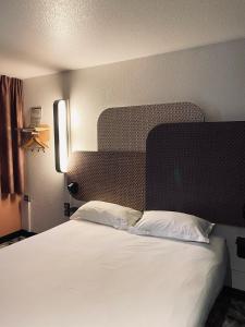 拉特斯B&B HOTEL Montpellier Sud Lattes的卧室配有一张白色大床和床头板