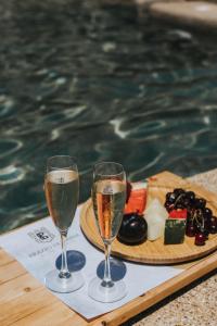 two glasses of champagne on a tray next to a pool at Brazzo di Maina in Oítilon