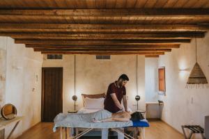 a man waxing a man laying on a bed at Brazzo di Maina in Oítilon