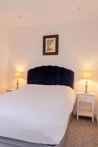 1 dormitorio con 1 cama blanca grande y 2 lámparas en Vertigo Boutique Sleeps 4 London, en Kingston upon Thames