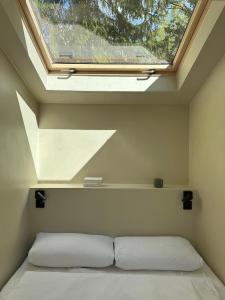 Un dormitorio con una cama y una ventana encima. en Tiny House mit Garten in der Lüneburger Heide, en Soltau