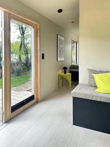 1 dormitorio con 1 cama y puerta corredera de cristal en Tiny House mit Garten in der Lüneburger Heide, en Soltau