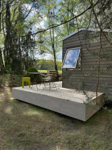 una cabina con tavolo e sedia gialla su una terrazza di Tiny House mit Garten in der Lüneburger Heide a Soltau