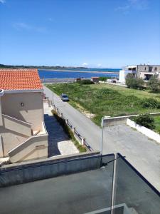 a balcony with a view of a street and the ocean at Apartments Anda Nin in Nin