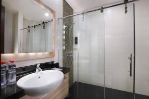 bagno con lavandino e doccia in vetro di Hotel Neo Gubeng by ASTON a Surabaya