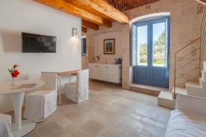 a living room with a table and a blue door at Borgofreddo Luxury Suite in Monopoli