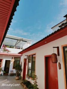 a white house with a red roof and a red door at Zhangjiajie Tingyutang Little Yard in Zhangjiajie