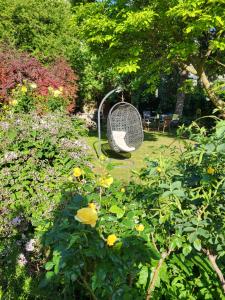 een schommel in een tuin met bloemen bij Hotel Pension Alte Mühle in Klosterneuburg