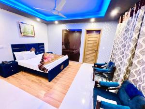 una camera con letto e soffitto blu di Family lodges a Islamabad