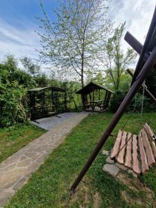 un groupe de bancs dans un parc avec balançoire dans l'établissement Гуцульська хата, à Yaremtche