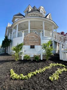 ein großes weißes Haus mit einem Schild davor in der Unterkunft Coastal Chateau in Ocean City