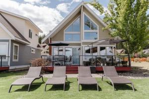 een huis met een patio met stoelen en een parasol bij Exceptional Cozy Cottage with Incredible View! in Kelowna