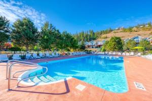 een zwembad in een resort met stoelen en bomen bij Exceptional Cozy Cottage with Incredible View! in Kelowna