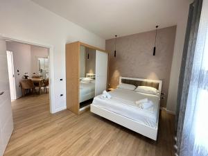 una camera con letto bianco e specchio di Arial Trinity Suites a Vlorë