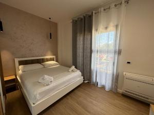 una camera con un letto bianco e una finestra di Arial Trinity Suites a Vlorë