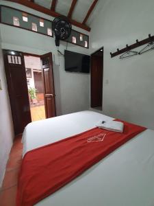 - une chambre avec un lit et une couverture rouge dans l'établissement Hotel Casa Posada Don Chepe, à San Gil