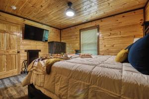 een slaapkamer met een groot bed in een houten kamer bij Adventure Retreat/Cabin/Pool+Hot Tub/Game Room+Theater in Sevierville