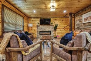 een woonkamer met banken en een open haard bij Adventure Retreat/Cabin/Pool+Hot Tub/Game Room+Theater in Sevierville