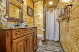 een badkamer met een wastafel en een toilet in een blokhut bij Adventure Retreat/Cabin/Pool+Hot Tub/Game Room+Theater in Sevierville