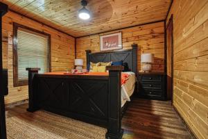 een slaapkamer met een bed in een blokhut bij Adventure Retreat/Cabin/Pool+Hot Tub/Game Room+Theater in Sevierville