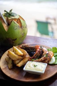 a plate of food with meat and french fries on a table at Maremegmeg Beach Club in El Nido