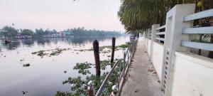 un cuerpo de agua con una cerca al lado en Captains Cabin backwater resort, en Alleppey