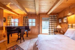 ein Schlafzimmer mit einem Bett und einem Klavier in einem Zimmer in der Unterkunft Mezdiva in Megève