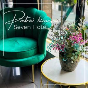 een groene stoel en een tafel met een potplant bij Seven Hotel Bytom - Katowice in Bytom