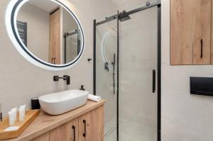 a bathroom with a sink and a mirror at Apartamenty z Jedną Sypialnią Aleja Kopisto w Rzeszowie by Noclegi Renters in Rzeszów