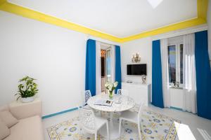 uma sala de estar azul e branca com uma mesa e cadeiras em Villa Flavio Gioia em Positano