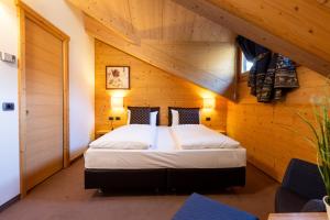 - une chambre avec un lit dans une pièce en bois dans l'établissement Hotel Cardo, à Valdidentro