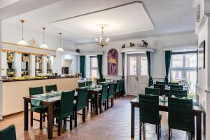 a dining room with tables and green chairs at Hotel Bristol in Kielce